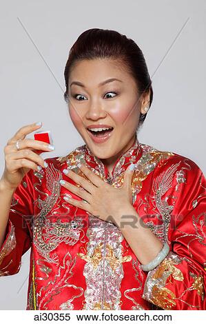 Woman wearing traditional Chinese jacket holding Mahjong tile looking surprised View Large Photo Image Stock Photography - Woman wearing traditional Chinese jacket holding Mahjong tile looking surprised. Fotosearch