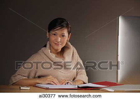 Woman working at desk with computer View Large Photo Image Stock Photo - Woman working at desk with computer. Fotosearch