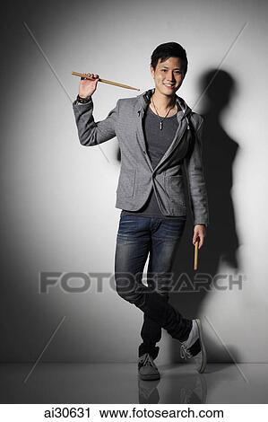Young man holding drumsticks and smiling View Large Photo Image Stock Image - Young man holding drumsticks and smiling. Fotosearch
