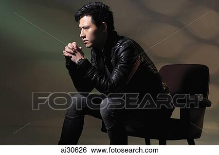 Young man sitting in chair thinking View Large Photo Image Stock Photograph - Young man sitting in chair thinking. Fotosearch