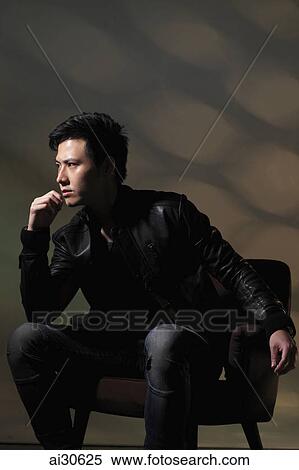 Young man sitting in chair thinking View Large Photo Image Stock Photography - Young man sitting in chair thinking. Fotosearch