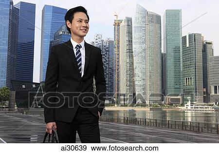 Young man wearing a suit standing in front of buildings. View Large Photo Image Stock Photo - Young man wearing a suit standing in front of buildings.. Fotosearch