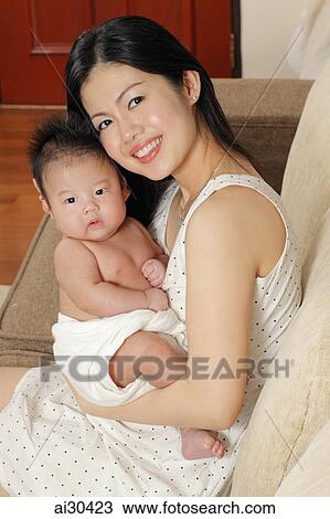 Young mother holding her baby and smiling View Large Photo Image Stock Image - Young mother holding her baby and smiling. Fotosearch