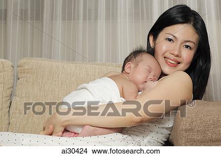 Young mother holding her sleeping baby View Large Photo Image Picture - Young mother holding her sleeping baby. Fotosearch