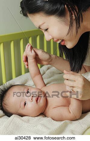 Stock Photo - Young mother playing with her baby. Fotosearch