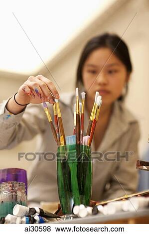 Young woman, out of focus, choosing paintbrushes in an art studio View Large Photo Image Stock Photo - Young woman, out of focus, choosing paintbrushes in an art studio. Fotosearch