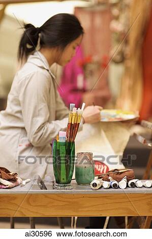 Young woman painting in an artist studio View Large Photo Image Stock Photograph - Young woman painting in an artist studio. Fotosearch