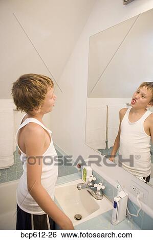 Boy making faces in bathroom mirror View Large Photo Image Stock Photograph - Boy making faces in bathroom mirror. Fotosearch