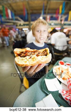 Stock Photo - Boy with half eaten hamburger. Fotosearch