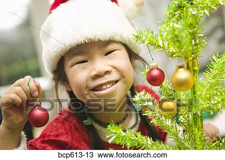 Closeup of girl decorating Christmas tree View Large Photo Image Stock Image - Closeup of girl decorating Christmas tree. Fotosearch