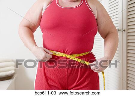 Closeup of overweight woman measuring waist View Large Photo Image Stock Image - Closeup of overweight woman measuring waist. Fotosearch
