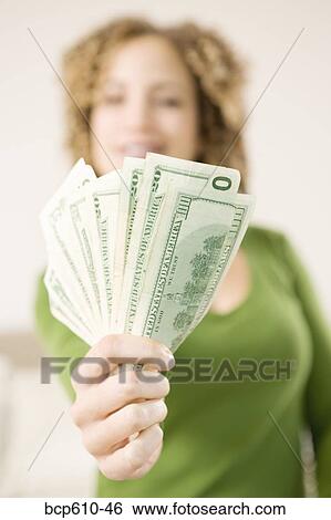 Stock Photograph - Closeup of woman's handful of money. Fotosearch
