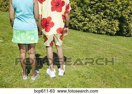 Couple holding hands on sunny lawn View Large Photo Image Stock Image - Couple holding hands on sunny lawn. Fotosearch
