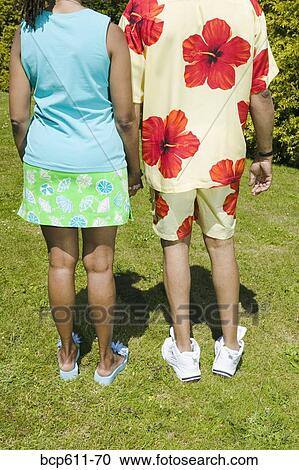Couple holding hands on sunny lawn View Large Photo Image Stock Image - Couple holding hands on sunny lawn. Fotosearch