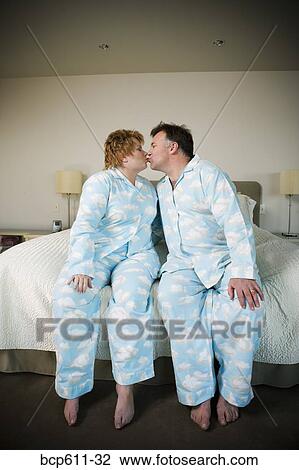 Stock Image - Couple in matching pajamas kissing. Fotosearch