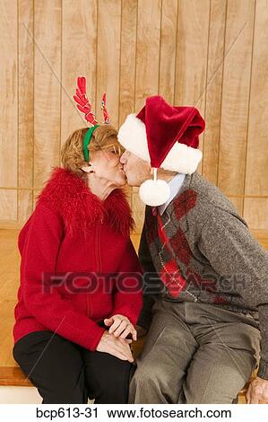 Elderly couple kissing at Christmastime View Large Photo Image Stock Image - Elderly couple kissing at Christmastime. Fotosearch
