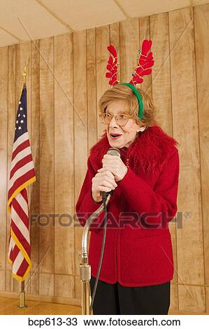 Elderly woman at microphone at Christmastime View Large Photo Image Stock Image - Elderly woman at microphone at Christmastime. Fotosearch