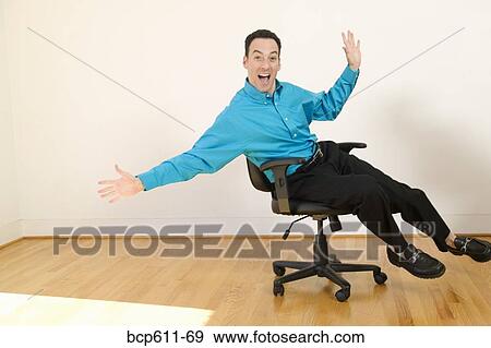 Enthusiastic businessman balancing in chair View Large Photo Image Stock Photo - Enthusiastic businessman balancing in chair. Fotosearch