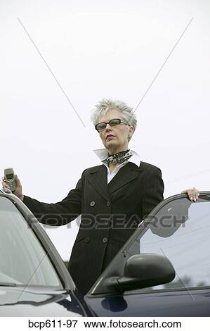 Fashionable middle aged woman with car View Large Photo Image Stock Photo - Fashionable middle aged woman with car. Fotosearch