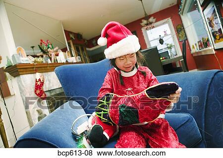 Girl in santa hat with Christmas stocking View Large Photo Image Stock Photo - Girl in santa hat with Christmas stocking. Fotosearch