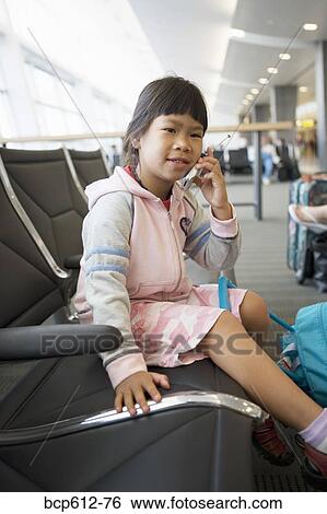 Girl with mobile phone at airport View Large Photo Image Stock Photograph - Girl with mobile phone at airport. Fotosearch