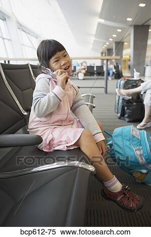 Stock Photography - Girl with mobile phone at airport. Fotosearch