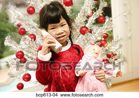 Girl with phone and doll on Christmas View Large Photo Image Picture - Girl with phone and doll on Christmas. Fotosearch