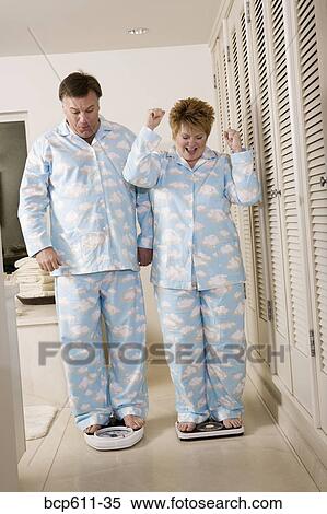 Happy couple on bathroom scales View Large Photo Image Stock Photography - Happy couple on bathroom scales. Fotosearch