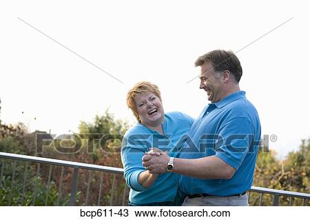 Happy middle aged couple dancing outside View Large Photo Image Stock Image - Happy middle aged couple dancing outside. Fotosearch