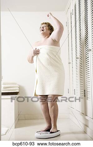 Happy overweight woman on bathroom scale View Large Photo Image Stock Image - Happy overweight woman on bathroom scale. Fotosearch