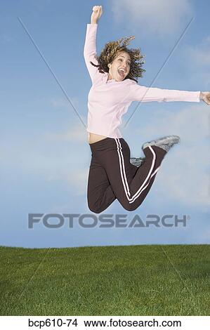 Picture - Happy woman jumping in midair. Fotosearch