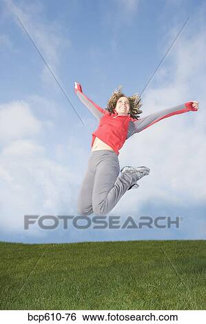 Stock Photograph - Happy woman jumping in midair. Fotosearch