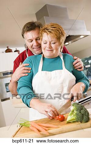 Stock Image - Husband and wife cooking together. Fotosearch