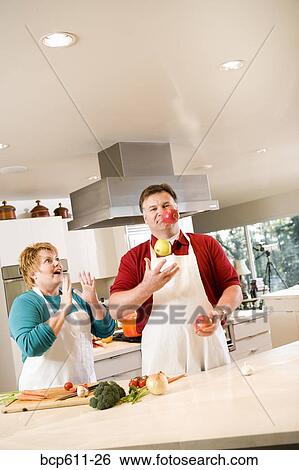 Husband juggling fruit with amazed wife View Large Photo Image Stock Photograph - Husband juggling fruit with amazed wife. Fotosearch