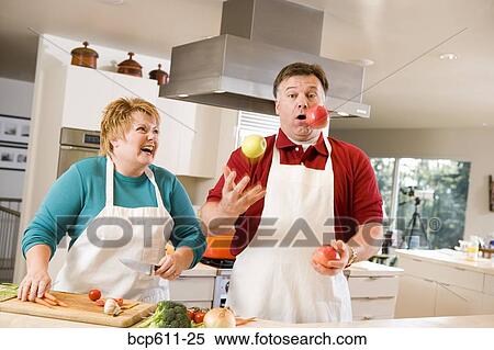 Husband juggling fruit with laughing wife View Large Photo Image Stock Photography - Husband juggling fruit with laughing wife. Fotosearch