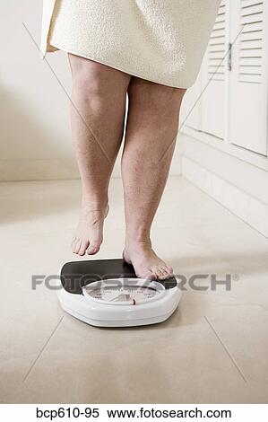 Legs of overweight woman stepping onto scale View Large Photo Image Stock Photography - Legs of overweight woman stepping onto scale. Fotosearch