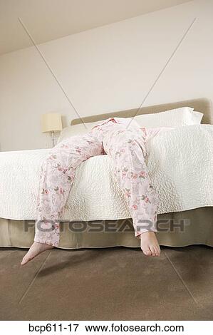 Legs of woman in pajamas hanging off bed View Large Photo Image Stock Photo - Legs of woman in pajamas hanging off bed. Fotosearch