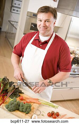 Man chopping vegetables in kitchen View Large Photo Image Stock Photo - Man chopping vegetables in kitchen. Fotosearch