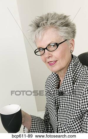 Middle aged businesswoman with coffee cup View Large Photo Image Stock Photo - Middle aged businesswoman with coffee cup. Fotosearch