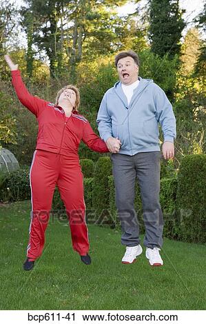 Middle aged couple jumping outdoors View Large Photo Image Stock Image - Middle aged couple jumping outdoors. Fotosearch
