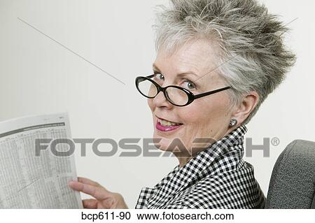 Middle aged woman reading financial section View Large Photo Image Stock Image - Middle aged woman reading financial section. Fotosearch