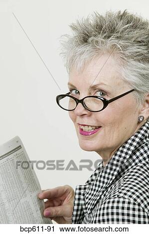 Middle aged woman reading financial section View Large Photo Image Stock Image - Middle aged woman reading financial section. Fotosearch