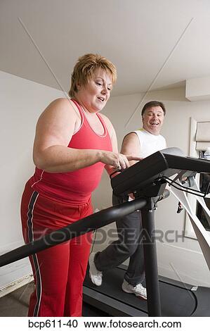 Overweight couple using exercise machines View Large Photo Image Stock Image - Overweight couple using exercise machines. Fotosearch