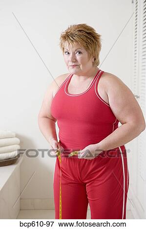 Overweight woman measuring waist View Large Photo Image Stock Photo - Overweight woman measuring waist. Fotosearch