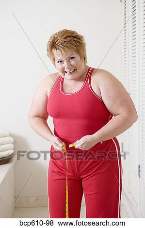 Overweight woman measuring waist View Large Photo Image Stock Photo - Overweight woman measuring waist. Fotosearch