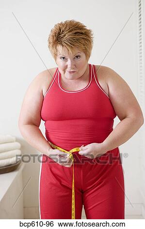 Overweight woman measuring waist View Large Photo Image Stock Photograph - Overweight woman measuring waist. Fotosearch