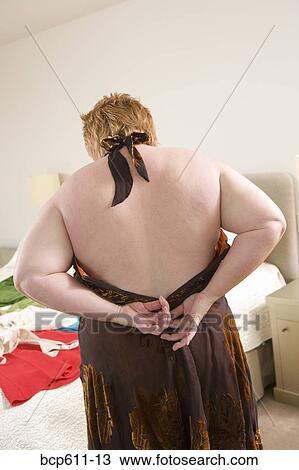 Overweight woman zipping up backless dress View Large Photo Image Stock Image - Overweight woman zipping up backless dress. Fotosearch