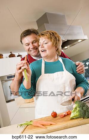 Playful couple cooking in kitchen View Large Photo Image Stock Image - Playful couple cooking in kitchen. Fotosearch