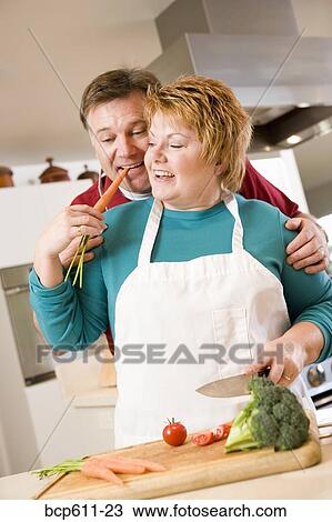 Playful couple cooking in kitchen View Large Photo Image Stock Image - Playful couple cooking in kitchen. Fotosearch