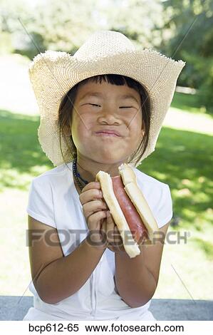 Portrait of girl eating hot dog outside View Large Photo Image Stock Photography - Portrait of girl eating hot dog outside. Fotosearch